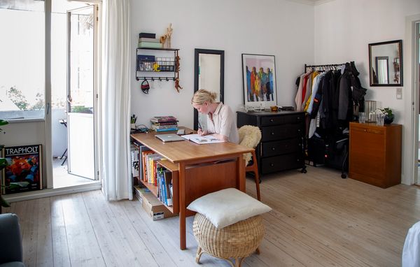 Ung kvinde sidder ved et skrivebord og skriver i en notesbog. Hurtigst muligt i eget hjem