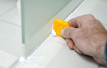 Overskydende silikonefuge fjernes efter fugning mellem bruseniche og fliser