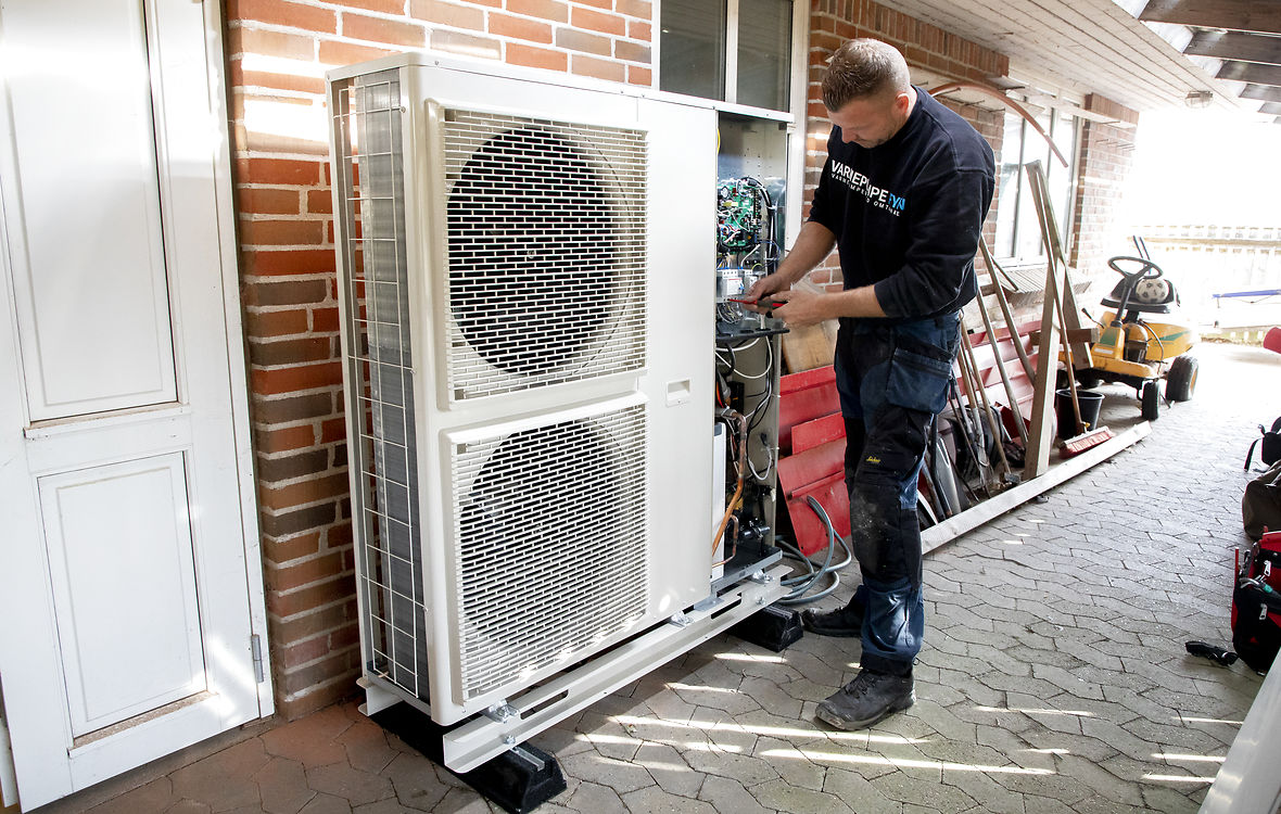 Installatør installerer ny varmepumpe i hus