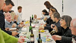 Familie og venner skåler til havefest i telt